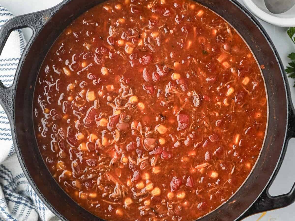 Adding additional ingredients to leftover pulled pork in the large stock pot for Pulled Pork Chili reipce