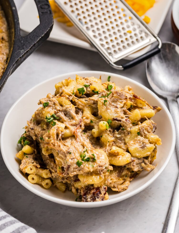 Creamy smoked brisket mac and cheese topped with shredded cheese and fresh parsley.