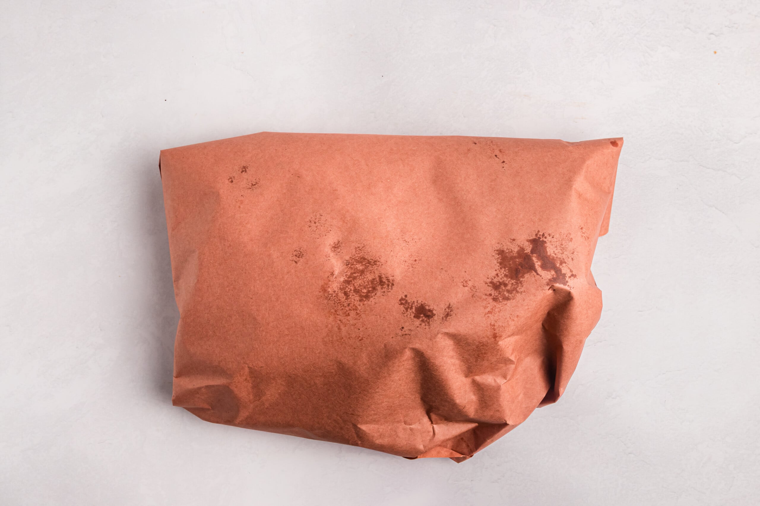 Smoked brisket wrapped in butcher paper to continue cooking.
