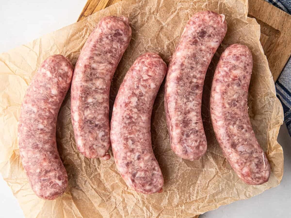 Uncooked sausage links on paper lined cutting board for Smoked Sausage recipe
