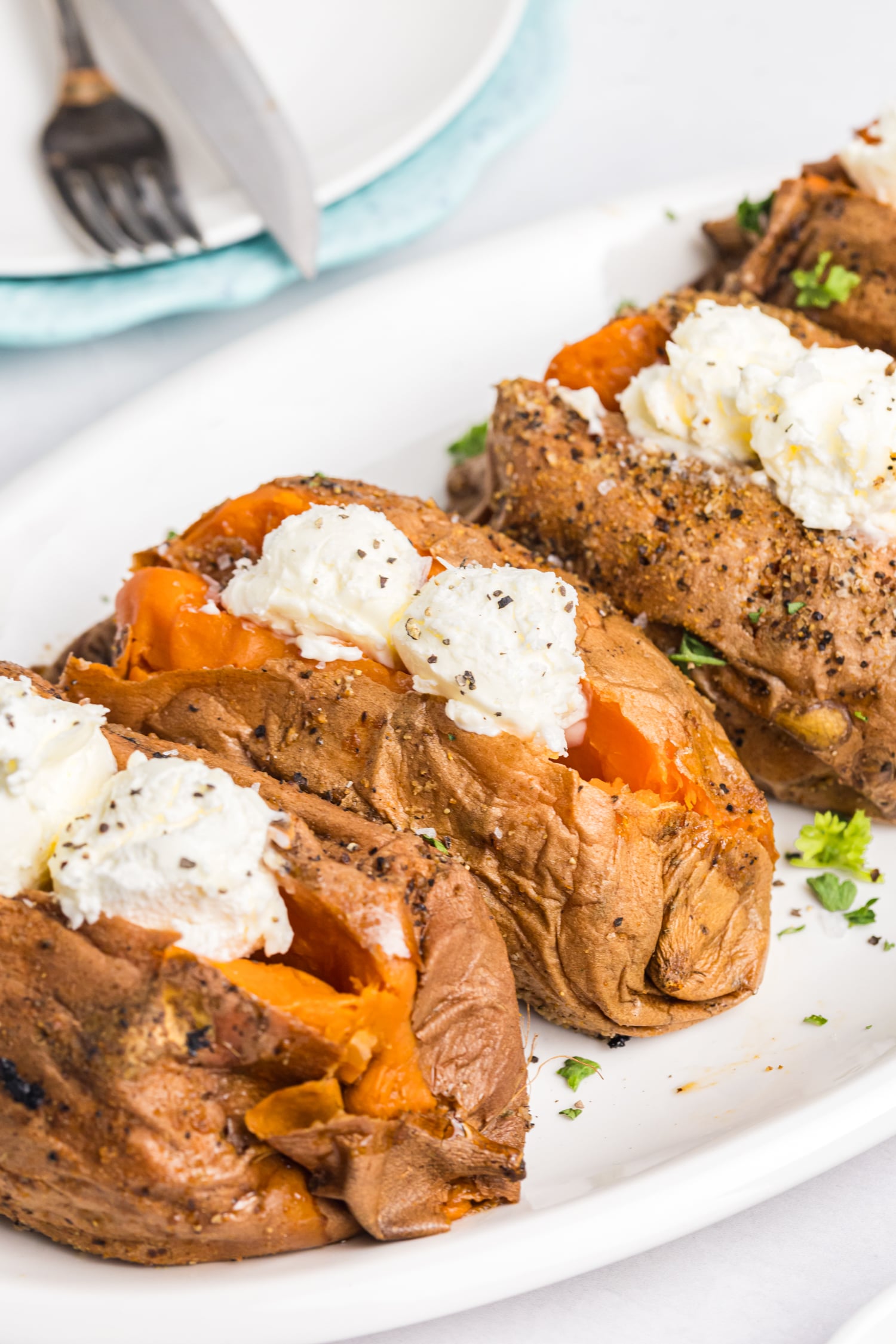 Smoked sweet potatoes split open and topped with butter, salt and pepper.