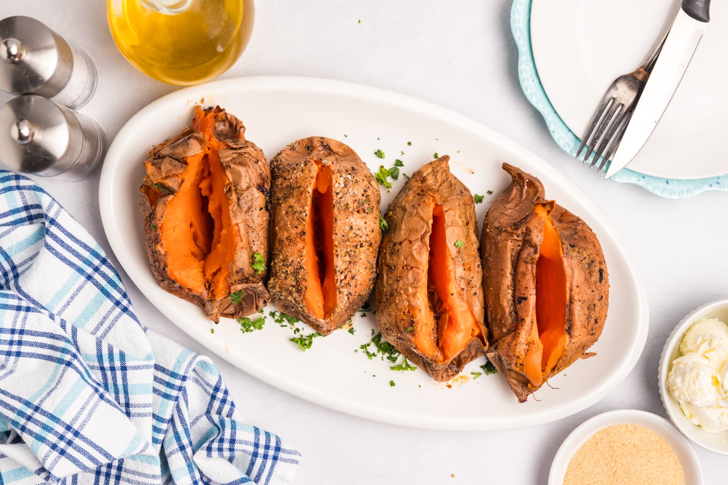 Smoked sweet potatoes split open and arranged on a serving platter.